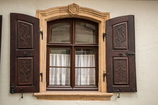Old window made of stone and wood with brown shutters