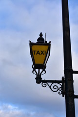 Fototapeta na wymiar Taxi streetlight with yellow glass and black iron. London, United Kingdom.