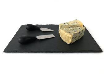 Different Varieties of Cheese and Two Knife Set on a Black Slate Board isolated on White