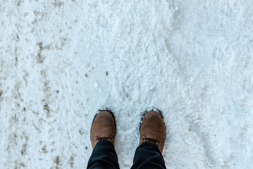 Mans feet in winter boots on the fresh snow.