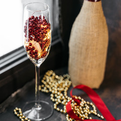 Wine glass and bootle with a red heart with pearls against dark background, valentine's day concept