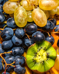 Fresh fruit salad made of banana, kiwi, and grapes pieces