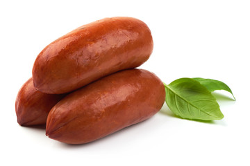 Delicious Smoked Sausages with basil leaves, close-up, isolated on a white background