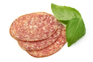 Thinly Sliced Salami with basil leaves, isolated on a white background. Close-up