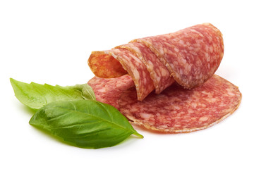 Smoked Salami Slices with basil leaves, isolated on a white background. Close-up