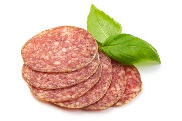 Italian Semi-dry Sliced Sausage with basil leaves, isolated on a white background. Close-up