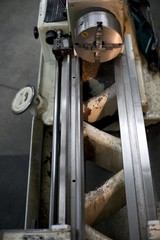 Lathe machine for metal cutting, machinery center background.