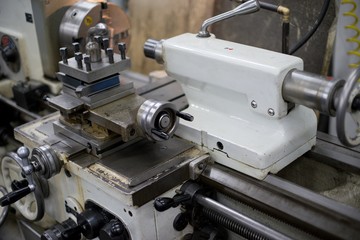 Lathe machine for metal cutting, machinery center background.