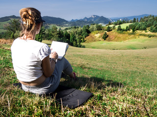 Woman artist working outdoors on hillside