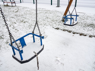 Playground swing covered with snow