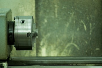 Lathe machine for metal cutting, machinery center background.