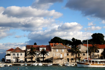 Fototapeta na wymiar Small fishing boats and traditional Mediterranean houses on promenade in Sutivan, island Brac, Croatia.