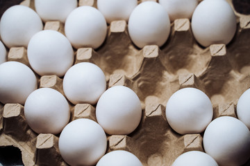 White chicken eggs in a cardboard box with empty space, background