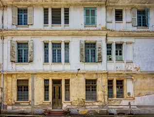 Fototapeta na wymiar Facade of old building with wooden door and wooden windows with glass