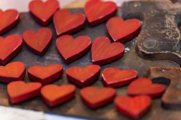 Red wooden hearts for sale at the market. Close up picture shot indoors in a christmas crafts market