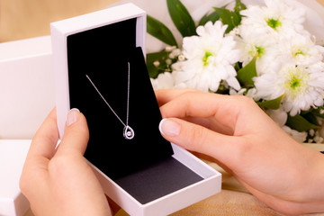 hand with jewelry gift box and white flowers