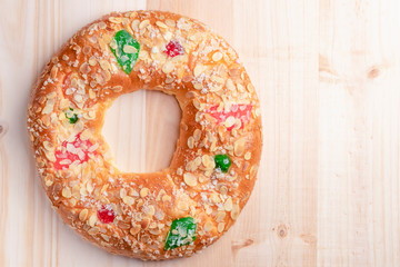 Spanish typical Epiphany cake Roscon de Reyes on a wooden background