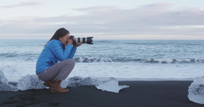 Photographer taking photos in nature on Iceland Diamond Beach with Ice. Iceland.