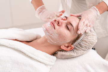 The doctor removes the gel from the patients face and apply a therapeutic cream. Anti acne...