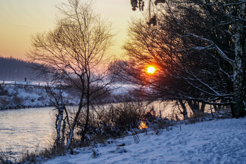 Sonnenuntergang am Fluss, tiefstehende Sonne durch die Bäume am Rand des Flusses. Wunderbare...