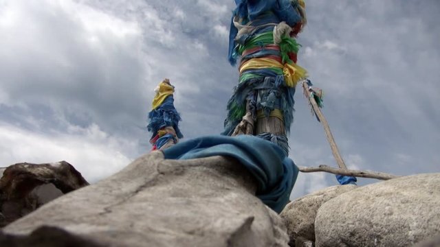 Shaman obo sacrifices on stones on background of clouds in Mongolia.