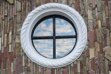 round window reflects the sky and clouds