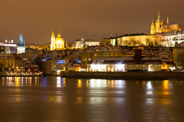 Fototapeta na wymiar Night snowy Christmas Prague Lesser Town with gothic Castle above River Vltava, Czech republic