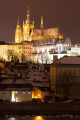Fototapeta na wymiar Night snowy Christmas Prague Lesser Town with gothic Castle above River Vltava, Czech republic