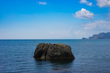 Fototapeta na wymiar Seascape with a large rock in the sea under the blue sky.