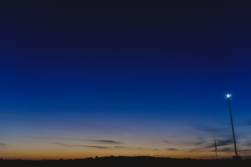 Sky background at dusk with silhouettes of trees and horizon.