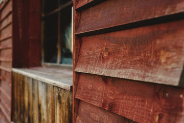 Background of aged wooden boards with reddish tones and window in the background.