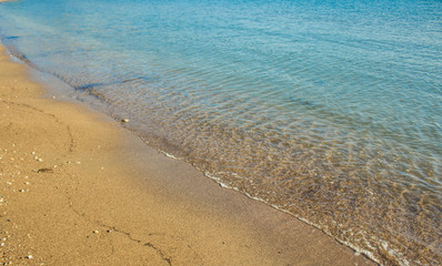sand beach on sea shoreline with beautiful blue water background texture wallpaper pattern summer vacation concept