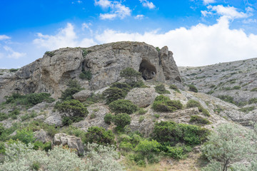 Fototapeta na wymiar Natural landscape with rocks covered with vegetation against a blue sky.