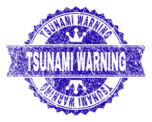 Obraz premium TSUNAMI WARNING rosette stamp seal watermark with grunge texture. Designed with round rosette, ribbon and small crowns. Blue vector rubber watermark of TSUNAMI WARNING caption with scratched texture.