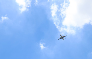 Image of an airplane is flying  in blue cloudy sky to the destination. The modern way of transportation in the world. The symbol of going directly to target. 