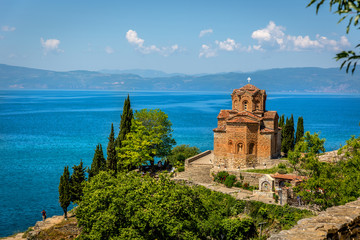 Fototapeta na wymiar An orthodox church with the beautiful Ohrid lake in a blue sky day