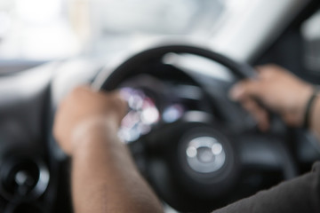 Men's hand holding the steering wheel