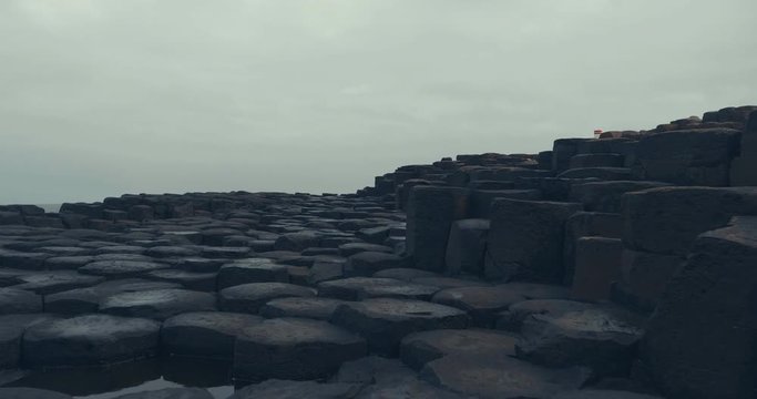 hand hold shoot view of walking on the giant causeway hexagon stone and move forward 