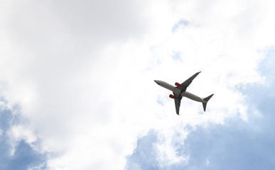 An airplane is flying  in cloudy blue sky. The way of transportation in modern world. 