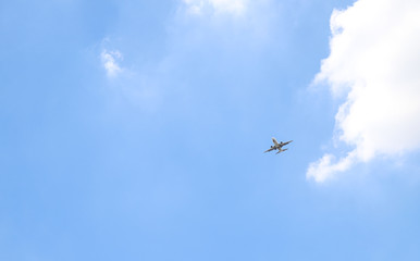 An airplane is flying  in cloudy blue sky. The way of transportation in modern world. 