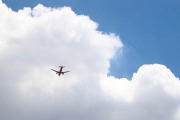 An airplane is flying  in cloudy blue sky. The way of transportation in modern world.  The minimal art background. 