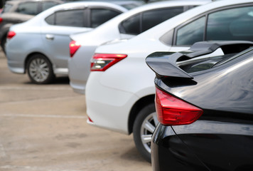 Closeup of rear side of black car park in parking area in sunny day.