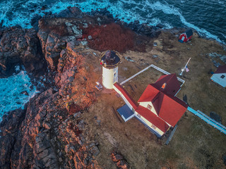 Aerial drone image of The Nubble Lighthouse on its rocky island ion a winter morning sunrise