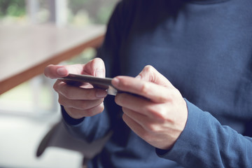 Close up of man hands playing a game on a mobile smartphone during leisure time.