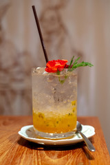 passion fruit juice in her hands on the vintage wooden background. Closeup, Select focus