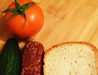 Ingredients for the salad. Fresh cucumbers and tomatoes. Wheat bread and canned green peas.