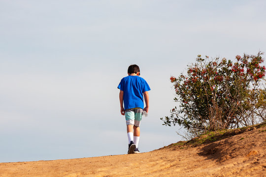 Child reaching the peak of a hill at Aliso & Woods Canyon Wilderness Park trail in Laguna Beach.  Hiking trail great for excercise