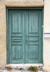 Wooden worn green door, closed. Traditional house facade, old town of Plaka, Athens Greece