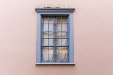 Grey old fashioned wooden window on pink pastel wall, old town Plaka, Athens Greece