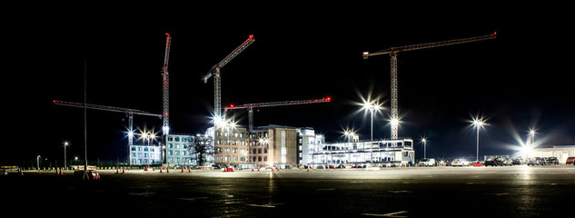 Building site with cranes by night